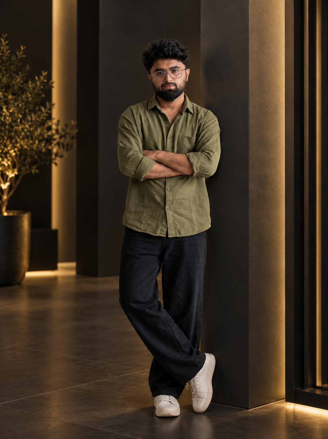 Mohammad Shahzeb Iqbal standing in olive shirt and dark trousers in modern architectural interior